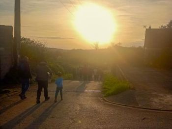 Groupe de personnes qui marchent dans un village au crépuscule