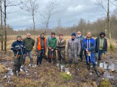 Photo de groupe en extérieur d'une dizaine d'hommes pour un chantier d'entretien de tourbière