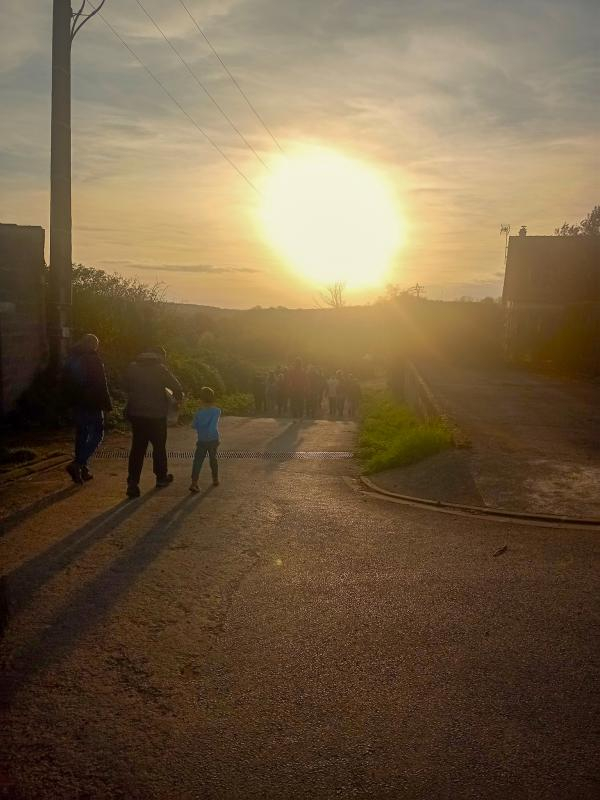 Groupe de personnes qui marchent dans un village au crépuscule