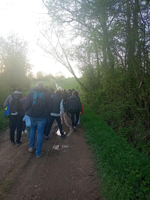 Groupe de personnes qui marchent sur un chemin de campagne au crépuscule