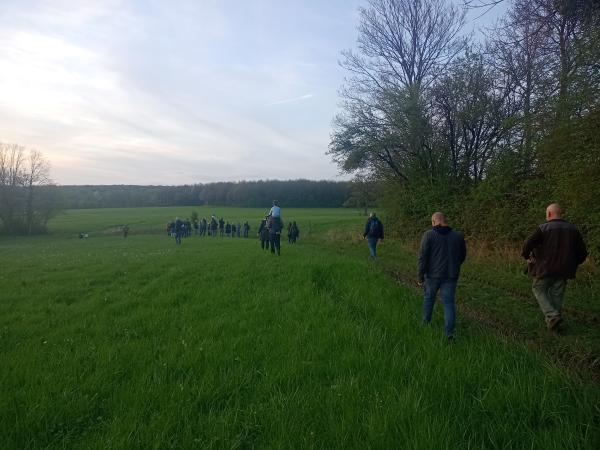 Groupe de personnes qui marchent dans la campagne au crépuscule