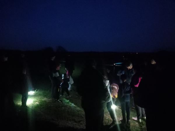 Groupe de personnes avec des lampes torches à la campagne de nuit